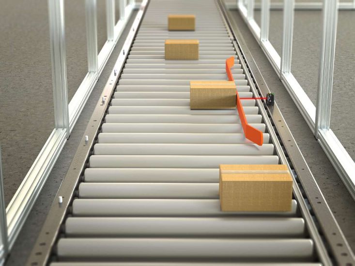 The Q20-2 sensor being used in a push-arm alignment conveyor application to align packages