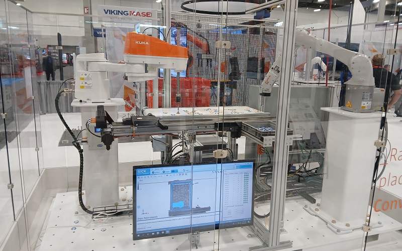 KUKA Pick-and-place robots working in tandem for conveyor belt placement.